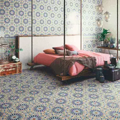 Dormitorio con suelo y paredes cubiertos de **azulejos Alhambra** de diseño geométrico. Cama suspendida y decoración exótica.