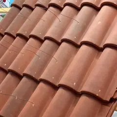 Detalle de la colocación teja árabe, con alambres finos sujetando las piezas sobre una estructura de madera.