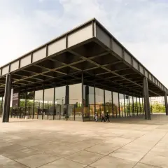 Edificio de cristal y acero, ejemplo de arquitectos contemporáneos. Fachada minimalista con voladizos y pilares negros.