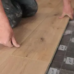 Man instalando tarima flotante, una forma fácil de cambiar suelo sin obra.