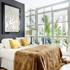 Ideas para diseñar tu habitacion: cama con manta peluda, cuadros abstractos y mucha luz natural.