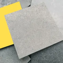 Muestras de suelos de piedra natural en tonos grises y un toque de amarillo vibrante.