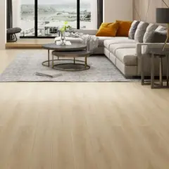 Amplio salón moderno con suelo de **pavimento spc** de madera clara, sofá gris, mesa de centro y vistas al exterior.