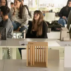 Estudiantes observan maquetas de arquitectura en una exposición. Son parte de las salidas de arquitectura en España.