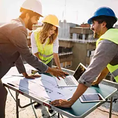 Equipo revisa planos en obra. La **dirección de obra y dirección de ejecución** se coordina para el éxito del proyecto.