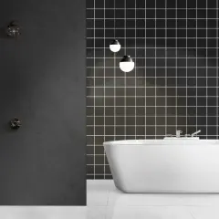 Modern bathroom with a freestanding white tub and a dark tiled wall. Ideal for **revestimiento paredes baño sin obras**.