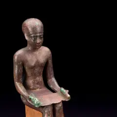 Estatua de bronce de Imhotep, el primer arquitecto de la historia, sentado con un papiro.