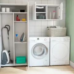 Lavaderos ideas: aspiradora, plancha y lavadora en un espacio organizado con estantes.