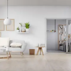 Sala de estar minimalista con sofá gris, mesa de centro de madera y suelo de madera clara, mostrando varios tipos de suelo.