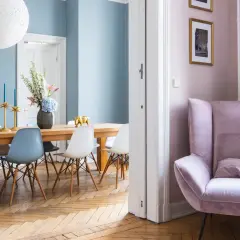 Elegantes casas de diseño interiores: comedor con sillas modernas y un sillón rosa acogedor.