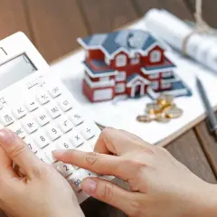 Calculadora en mano, planificando la compra de una casa. Esto es autopromoción: invertir en tu futuro.