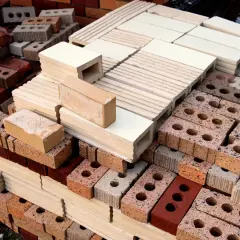 Montón de ladrillos de construcción tradicional, apilados en diferentes tamaños y colores, listos para crear estructuras sólidas.