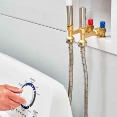 Mangueras de lavadora conectadas a la toma de agua. Evitar el golpe de ariete en viviendas es clave para la durabilidad de las tuberías.