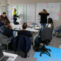 Equipo discutiendo un plan de proyecto en una sala de reuniones, aplicando principios de **lean construction** para optimizar el proceso.
