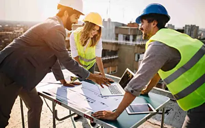 Equipo revisa planos en obra. La **dirección de obra y dirección de ejecución** se coordina para el éxito del proyecto.