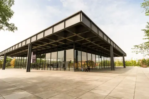 Edificio de cristal y acero, ejemplo de arquitectos contemporáneos. Fachada minimalista con voladizos y pilares negros.