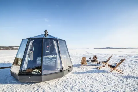 Modernas casas de cristal en el Polo Norte, con camas acogedoras y sillas al aire libre para disfrutar del paisaje nevado.