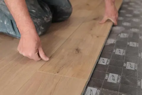 Man instalando tarima flotante, una forma fácil de cambiar suelo sin obra.