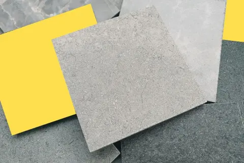 Muestras de suelos de piedra natural en tonos grises y un toque de amarillo vibrante.