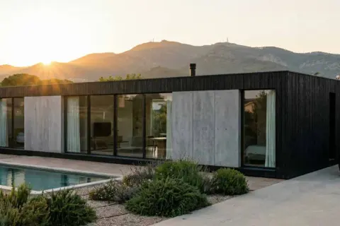 Casa moderna con piscina y coche eléctrico, estructura de **steel frame** visible en su diseño minimalista.