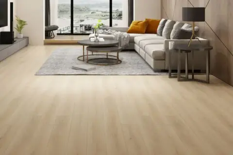 Amplio salón moderno con suelo de **pavimento spc** de madera clara, sofá gris, mesa de centro y vistas al exterior.