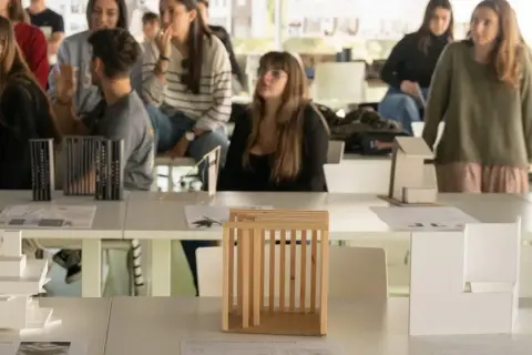 Estudiantes observan maquetas de arquitectura en una exposición. Son parte de las salidas de arquitectura en España.