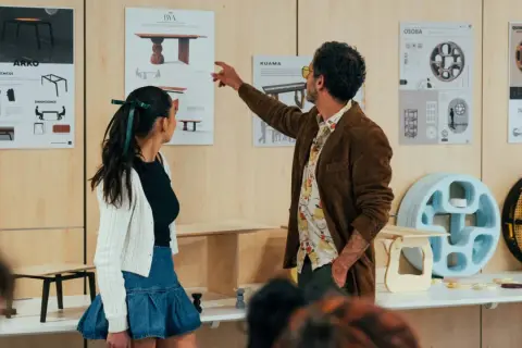 Un hombre y una mujer observan diseños de muebles. Para ser diseñador de interiores, hay que estudiar materiales, formas y funcionalidad.