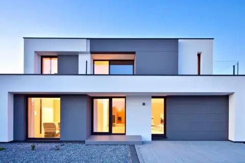 Moderna casa con amplios ventanales y puerta de garaje gris. Un ejemplo de construcción de viviendas contemporáneas.