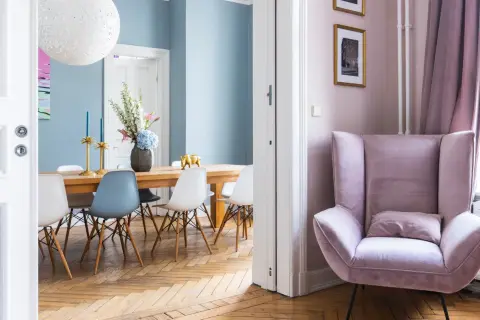 Elegantes casas de diseño interiores: comedor con sillas modernas y un sillón rosa acogedor.