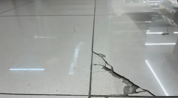 Detalle de una baldosa rota con grietas visibles. Aprende como reparar una baldosa rota sin cambiarla con este método.