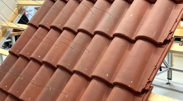 Detalle de la colocación teja árabe, con alambres finos sujetando las piezas sobre una estructura de madera.