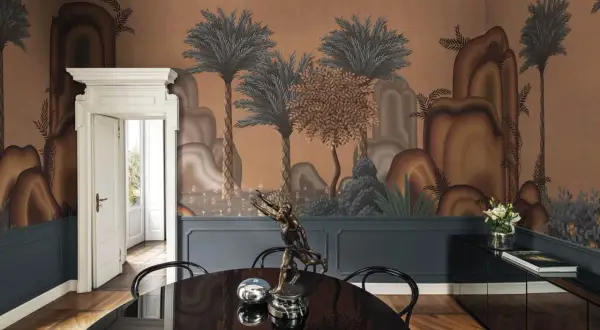 Un comedor con papel tapiz de paisaje exótico, inspirado en el diseño de interiores de universidades. Una escultura y mesa negra completan el espacio.