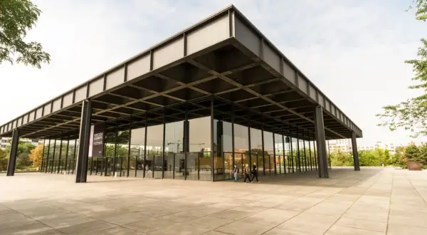 Edificio de cristal y acero, ejemplo de arquitectos contemporáneos. Fachada minimalista con voladizos y pilares negros.