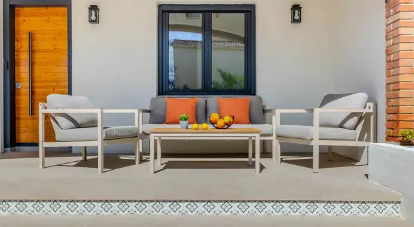 Un profesional que se dedica a embellecer ambientes ha creado este acogedor rincón exterior con sofá, sillones y mesa.