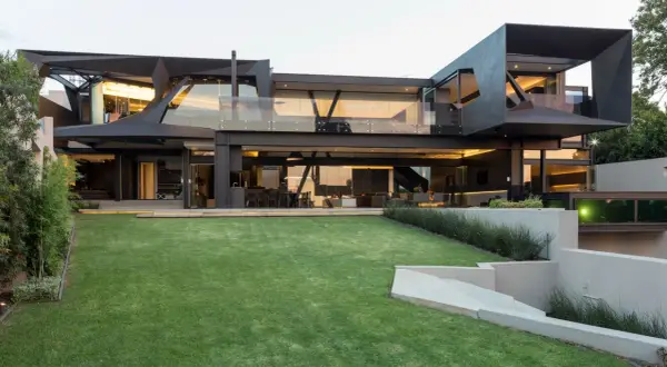 La casa mas moderna del mundo, con su diseño geométrico y cristaleras, se alza sobre un césped impecable.