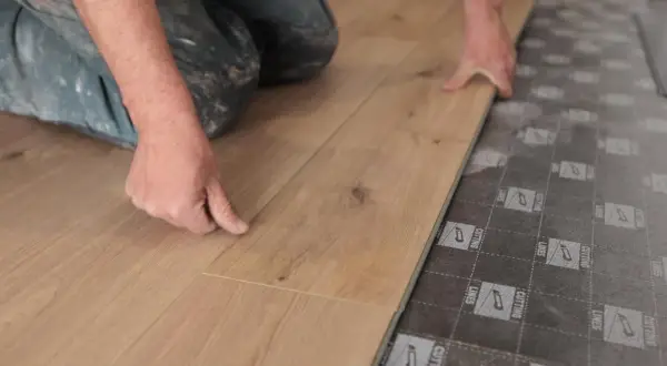 Man instalando tarima flotante, una forma fácil de cambiar suelo sin obra.
