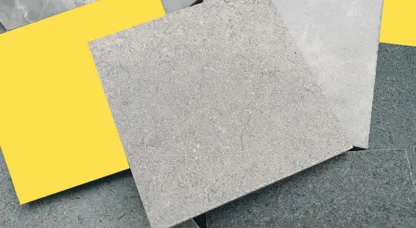 Muestras de suelos de piedra natural en tonos grises y un toque de amarillo vibrante.