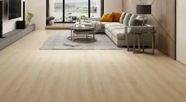 Amplio salón moderno con suelo de **pavimento spc** de madera clara, sofá gris, mesa de centro y vistas al exterior.
