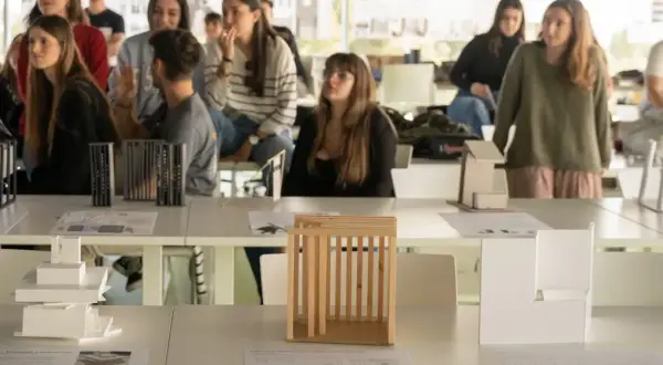 Estudiantes observan maquetas de arquitectura en una exposición. Son parte de las salidas de arquitectura en España.