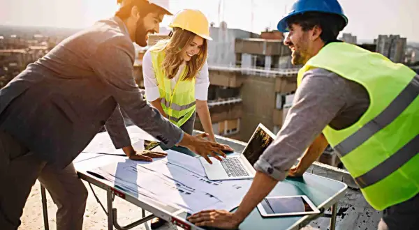 Equipo revisa planos en obra. La **dirección de obra y dirección de ejecución** se coordina para el éxito del proyecto.