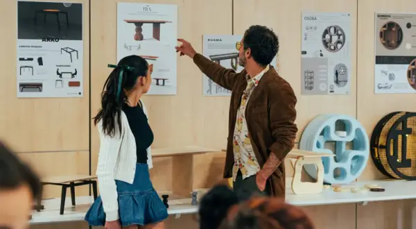Un hombre y una mujer observan diseños de muebles. Para ser diseñador de interiores, hay que estudiar materiales, formas y funcionalidad.