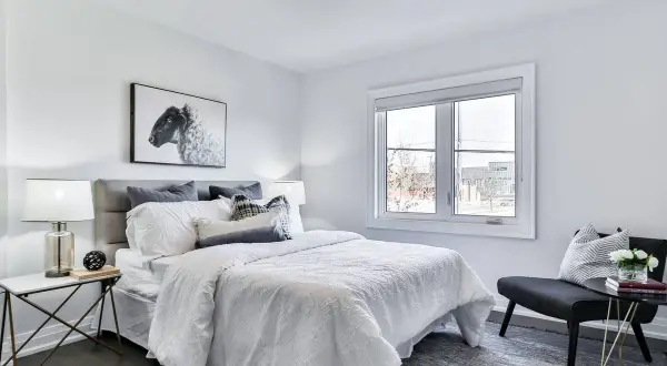 Habitación moderna con cama blanca, cuadros de ovejas y detalles para decorar habitacion.