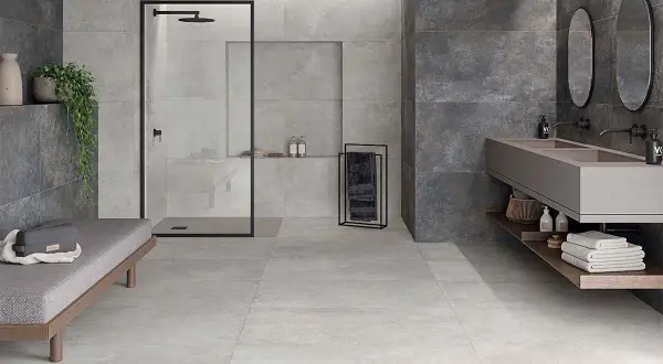 Baño moderno con ducha, lavabo doble y banco. La diferencia entre baldosa y azulejo se aprecia en los acabados de pared y suelo.