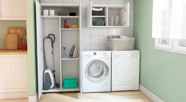 Lavaderos ideas: aspiradora, plancha y lavadora en un espacio organizado con estantes.
