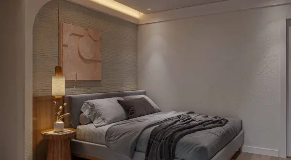 Un elegante diseño cuarto con cama gris, arte abstracto en tonos tierra y lámpara colgante.