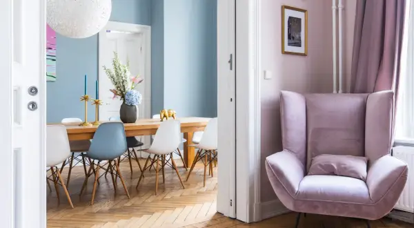 Elegantes casas de diseño interiores: comedor con sillas modernas y un sillón rosa acogedor.