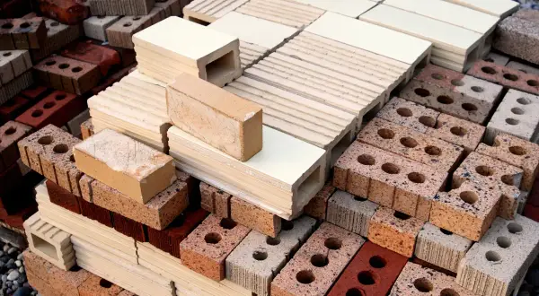 Montón de ladrillos de construcción tradicional, apilados en diferentes tamaños y colores, listos para crear estructuras sólidas.