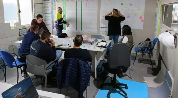 Equipo discutiendo un plan de proyecto en una sala de reuniones, aplicando principios de **lean construction** para optimizar el proceso.