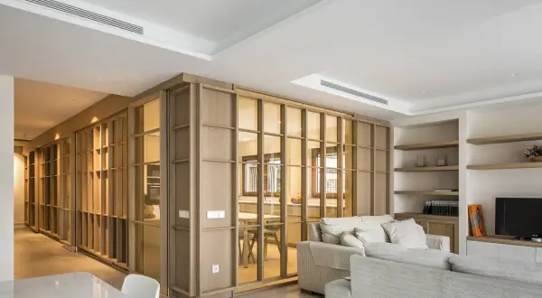 Un espacio moderno y luminoso, ideal para diseñar interiores. Muebles de madera y cristal separan ambientes, creando un hogar acogedor.