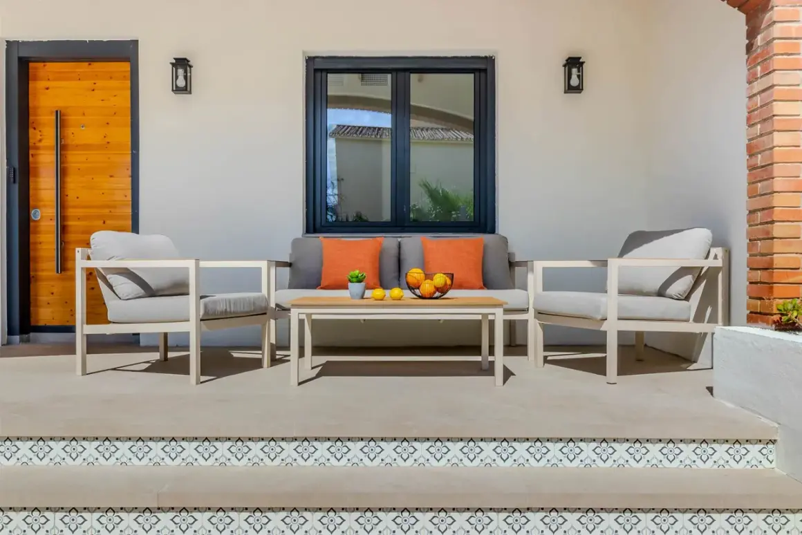Un profesional que se dedica a embellecer ambientes ha creado este acogedor rincón exterior con sofá, sillones y mesa.